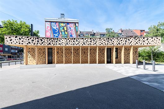 Außenansicht der Radstation der Hochschule Düsseldorf. Es handelt sich um ein Gebäude aus Holz mit einer elektronischen Zugangstür.